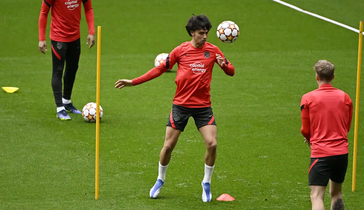 Penyerang Atletico Madrid Joao Felix (tengah) menyundul bola selama sesi latihan di stadion Wanda Metropolitano, Selasa (12/4/2022). Atletico Madrid bersua Manchester City pada leg kedua perempat final Liga Champions, Kamis 14 April 2022 dini hari WIB. (Pierre-Philippe MARCOU/AFP)