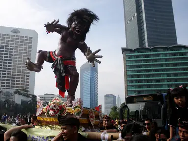 Sejumlah orang mengarak ogoh-ogoh saat Car Free Day di Bundaran HI, Jakarta, Minggu (19/3). Kegiatan tersebut untuk menyosialisasikan pawai ogoh-ogoh di Pura Agung Wira Satya Bhuana, Jakarta, pada Senin (27/3). (Liputan6.com/Angga Yuniar)