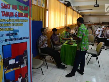 Petugas melakukan perekaman data E-KTP di SMKN 28, Jakarta, Kamis (10/1). Dukcapil Jaksel menyambangi 34 SMA/SMK sederajat sebagai program jemput bola perekaman data siswa yang akan masuk usia 17 tahun hingga Maret 2019 ini. (Merdeka.com/Imam Buhori)