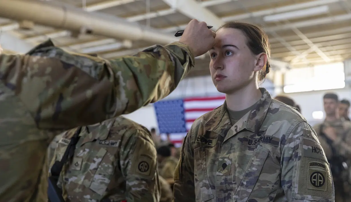 Seorang anggota Divisi Lintas Udara ke-82 Angkatan Darat AS menjalani pemeriksaan suhu tubuh sebagai bagian dari pemeriksaan COVID-19 saat tentara bersiap untuk ditempatkan ke Polandia dari Fort Bragg, North Carolina, AS, 14 Februari 2022. (AP Photo/Nathan Posner)