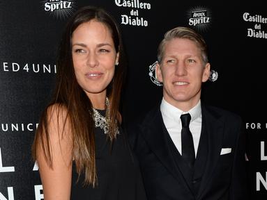 Gelandang Manchester United, Bastian Schweinsteiger (R) dan pacarnya, petenis Ana Ivanovic berpose di atas karpet merah saat tiba menghadiri "Inggris untuk UNICEF Gala Dinner" di Old Trafford, Manchester, Inggris, (29/11). (AFP PHOTO/OLI SCARFF)