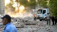 Petugas membersihkan puing-puing atap gedung yang runtuh sai gempa berkekuatan 5,6 magnitudo mengguncang Tirana, Albania (21/9/2019). Menurut lembaga survei Amerika Serikat, titik pusat gempa berada dekat Durres, kurang dari 40 kilometer sebelah barat ibu kota Tirana. (AFP Photo/Gent Shkullaku)