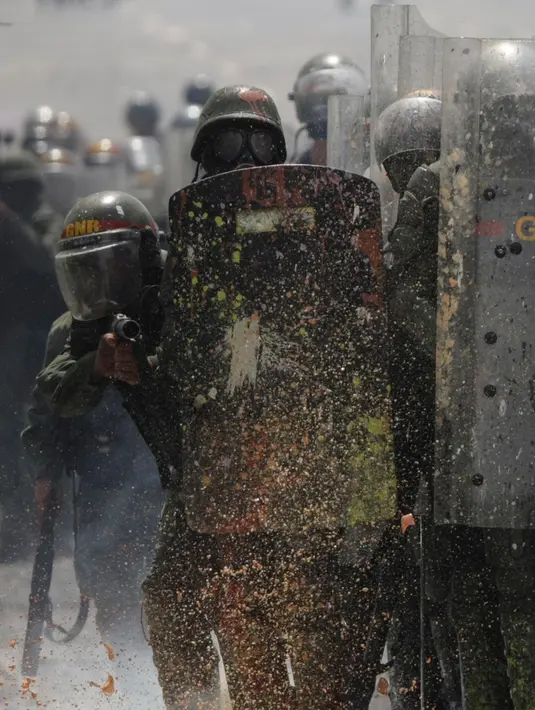 Botol berisi tinja dilemparkan pengunjuk rasa ke arah Garda Nasional Venezuela di Caracas, 10 Mei 2017. Demonstran anti-pemerintah kini menggunakan bom 'poopootov' untuk menyerang petugas yang menghalangi jalannya aksi demo. (AP Photo/Fernando Llano)