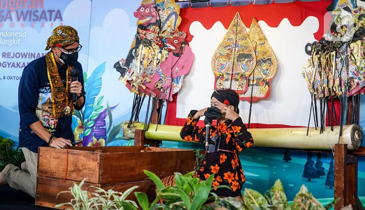 Menteri Parekraf berbincang dengan dalang cilik berusia 9 tahun Adimas Alby Ersani Widyaputra di desa wisata Rejowinangun, Yogyakarta, Jumat (08/10/2021). Guna menambah kreativitas Sanidaga Uno membelikan ponsel untuk  membantu membuat konten wayang dan wayang pandawa lima.(Liputan6.com/HO/Parekraf)