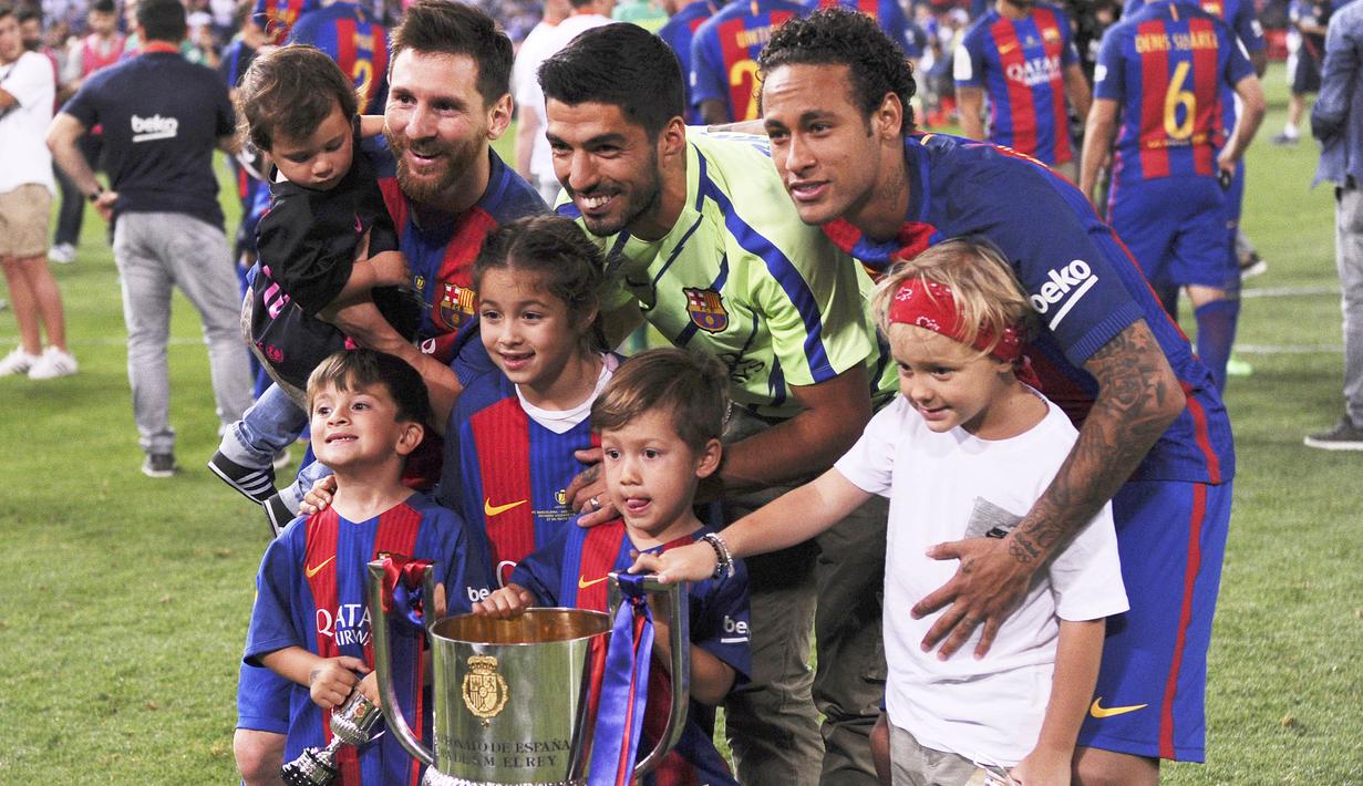 Trio MSN, Neymar Jr, Luis Suarez dan Lionel Messi melakukan selebrasi bersama anak-anak mereka usai berhasil menjuarai Copa del Rey dengan mengalahkan Deportivo Alaves di Stadion Vicente Calderon, Madrid, Sabtu, (27/5/2017). (AFP/Josep Lago)