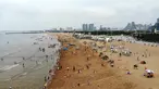 Foto yang diabadikan dari udara pada 9 Juli 2020 ini memperlihatkan orang-orang yang sedang menikmati waktu bersantai di sebuah pantai di Rizhao, Provinsi Shandong, China timur. (Xinhua/Wang Kai)