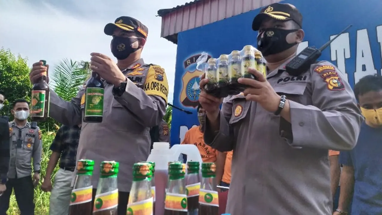 Kepala Polresta Pekanbaru dan Kepala Polsek Tampan memegang barang bukti jamu ilegal.