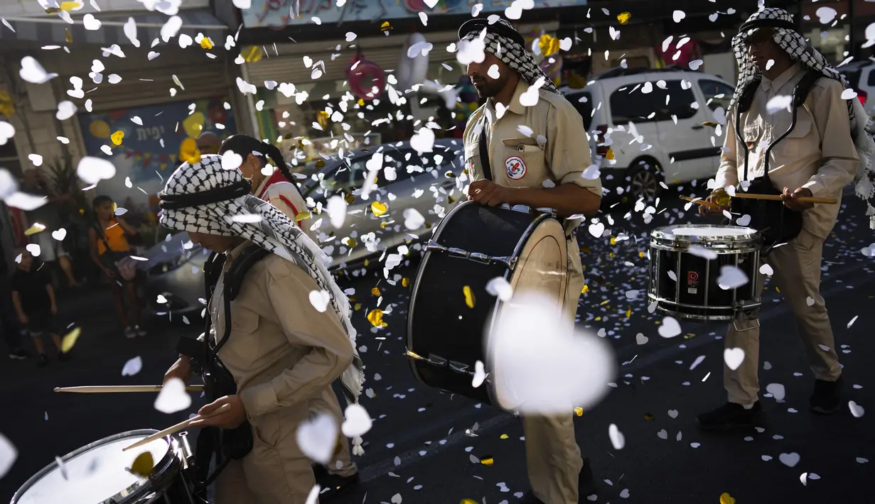 Warga Palestina Israel berbaris dalam parade pada festival Idul Adha di lingkungan campuran Yahudi-Arab, Jaffa, dekat Tel Aviv, Israel, 9 Juli 2022. Umat muslim seluruh dunia merayakan Idul Adha atau Hari Raya Kurban untuk memperingati kesediaan Nabi Ibrahim mengorbankan putranya. (AP Photo/Oded Balilty)