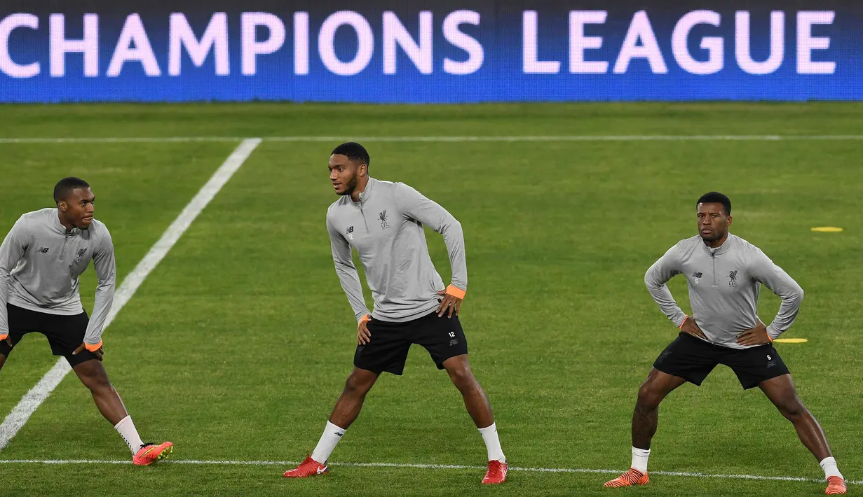 Striker Liverpool, Daniel Sturridge (kiri) bersama bek Joe Gomez (tengah) dan gelandang Georginio Wijnaldum melakukan pemanasan saat latihan jelang menghadapi Sevilla di stadion Ramon Sanchez Pizjuan di Sevilla (20/11). (AFP Photo/Cristina Quicler)