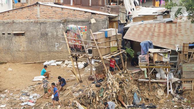 Anak-anak bermain di sekitar pemukiman bantaran Sungai Ciliwung, Jakarta, Jumat (17/7/2020). Badan Pusat Statistik menyebut tingkat kemiskinan di RI kini membengkak jadi 9,78 persen dari total populasi nasional akibat pandemi virus corona COVID-19. (Liputan6.com/Immanuel Antoniu)