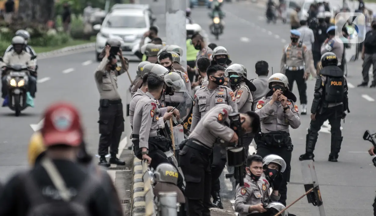 Aparat kepolisian berjaga di sekitar akses menuju Gedung DPR RI guna mengadang massa demonstrasi UU Cipta Kerja, Jakarta, Kamis (8/10/2020). Polri mengerahkan 2.500 personel BKO Brimob Nusantara untuk mengamankan unjuk rasa UU Cipta Kerja di Gedung DPR dan sekitarnya. (merdeka.com/Iqbal S. Nugroho)