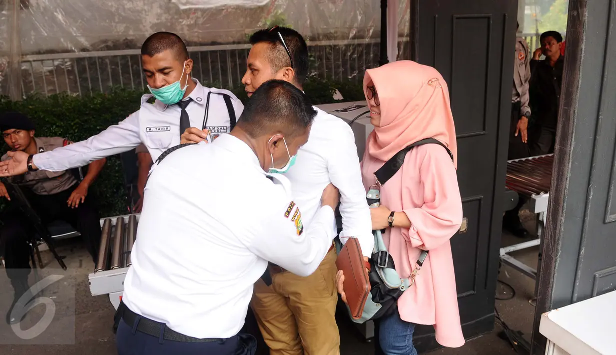 Petugas keamanan melakukan pemeriksaan tubuh pada pengunjung yang akan mengikuti sidang pembacaan putusan perselisihan hasil Pilkada 2015 di gedung Mahkamah Konstitusi, Jakarta, Senin (18/1/2016). (Liputan6.com/Helmi Fithriansyah)