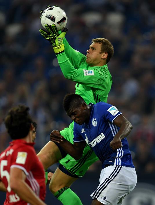 Kiper Bayern Munchen, Manuel Neuer, mengamankan bola dari pemain Schalke 04, Breel Embolo, dalam lanjutan Bundesliga di Veltins Arena, Gelsenkirchen, Sabtu (10/9/2016) dini hari WIB. (AFP/Patrik Stollarz)