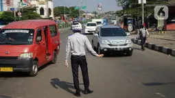 Petugas Dishub mengatur lalu lintas saat melakukan sosialisasi penggunaan masker kepada pengendara sepeda motor di kawasan Depok, Jawa Barat, Senin (20/7/2020). Setelah sosialisasi, Pemkot Depok akan menerapkan sanksi denda kepada warga yang melanggar. (Liputan6.com/Immanuel Antonius)