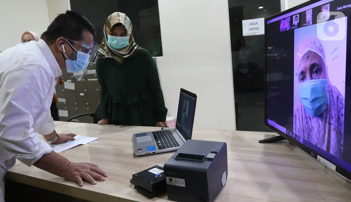 Wakil Gubernur DKI Ahmad Riza Patria berbincang secara virtual dengan salah satu pasien Covid-19 saat meninjau meninjau RSUD khusus Covid-19 di Pasar Minggu, Jakarta, Sabtu (3/10/2020). Kunjungan Riza untuk memastikan langsung penanganan pasien yang terpapar Covid-19. (Liputan6.com/Herman Zakharia)