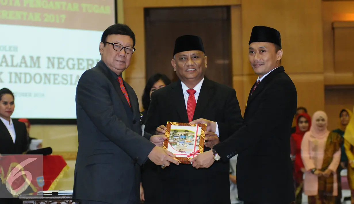 Mendagri Tjahjo Kumolo (kedua kiri) menyerahkan nota pengantar tugas dari Gubernur Gorontalo Rusli Habibie kepada Zudan Arif Fakrulloh (ketiga kanan) di Kemendagri, Jakarta, Kamis (27/10). (Liputan6.com/Helmi Fithriansyah)