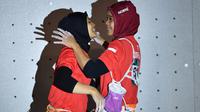 Peraih medali emas Indonesia Susanti Rahayu Aries berpelukan dengan peraih medali perak Puji Lestari usai pertandingan panjat tebing wanita Asian Games 2018 di Palembang (23/8). (AFP PHOTO / Adek Berry)