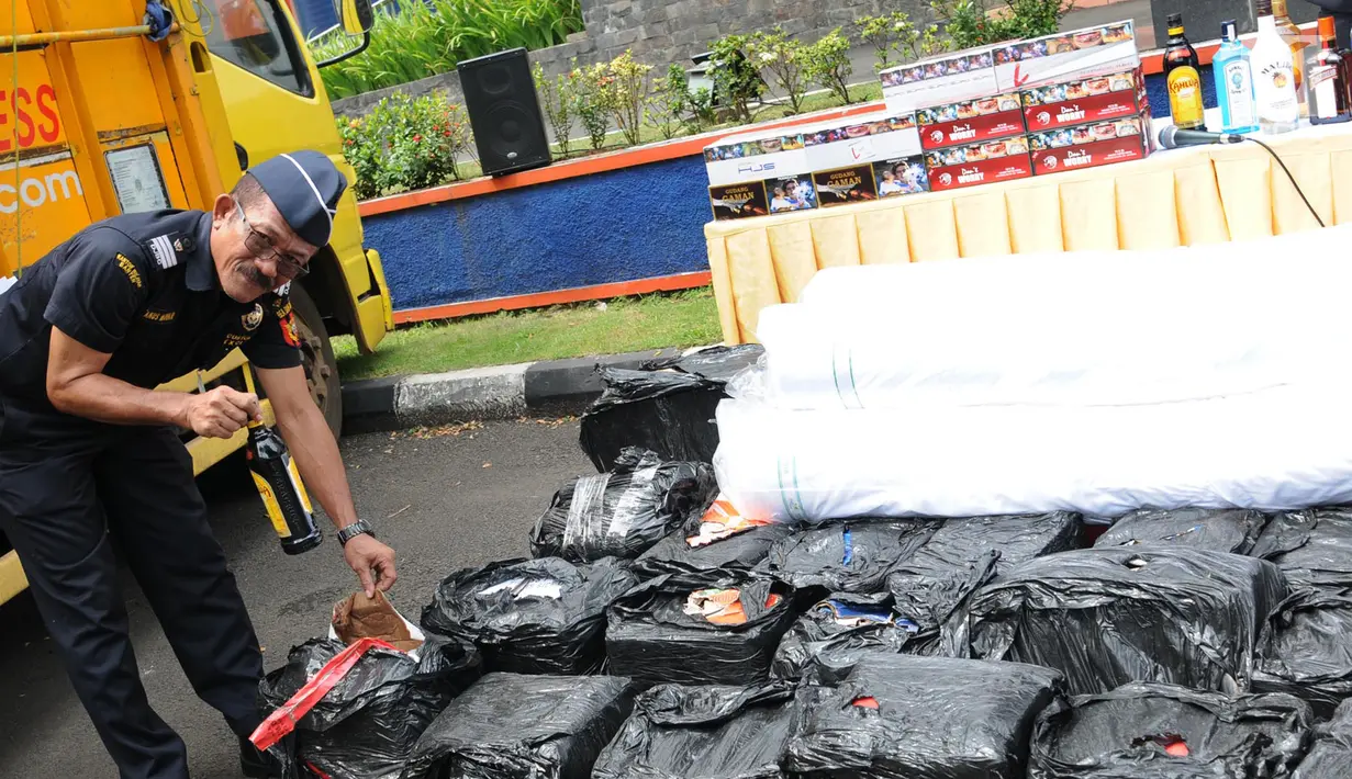 Petugas Kanwil Dirjen Bea dan Cukai Banten memeriksa sejumlah barang bukti di Banten (6/3). Barang bukti yang berhasil diamankan 7.743 tekstil barang impor, 14.940  minuman beralkohol illegal, dan 2.903.960 tembakau. (Merdeka.com/Arie Basuki)