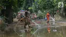 Sejumlah petugas pemadam kebakaran membersihkan sisa lumpur pascabanjir yang merendam kawasan Bukit Duri, Jakarta, Sabtu (4/1/2020). Meski banjir sudah mulai surut, jalan-jalan dan permukiman warga masih tertutup lumpur tebal. (merdeka.com/Imam Buhori)