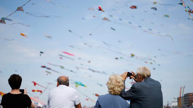 Orang-orang mengambil gambar selama Festival Layang-layang Internasional Dieppe ke-20 di Dieppe, Prancis, Minggu (9/9). Festival setiap dua tahun sekali sejak 1980 itu merupakan salah satu festival layang-layang terbesar di dunia. (AFP/CHARLY TRIBALLEAU)