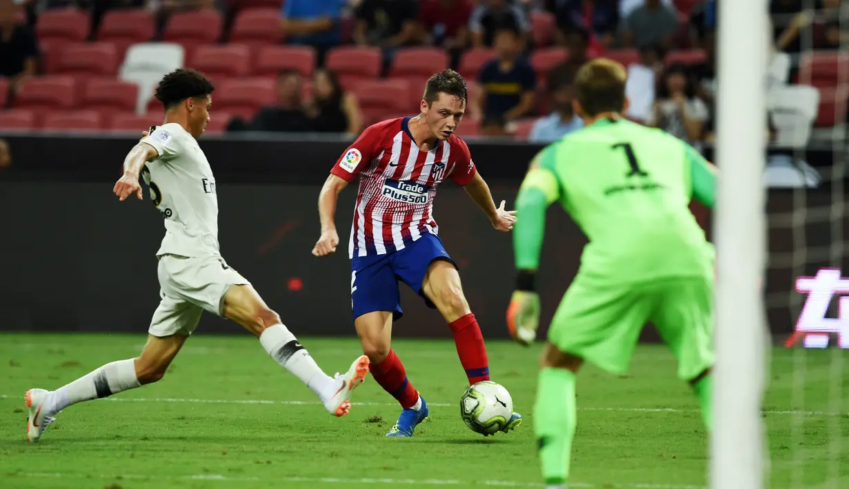 Pemain Atletico Madrid, Borja Garces, berusaha melewati pemain Paris Saint-Germain (PSG) pada laga ICC 2018 di Stadion Nasional Singapura, Senin (30/7/2018). PSG menang 3-2 atas Atletico Madrid. (AFP/Roslan Rahman)