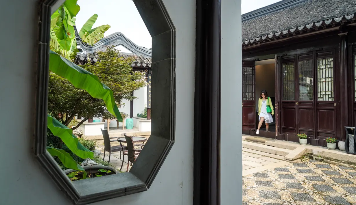 Seorang wanita berjalan di bagian Hotel Gusu Yard di Suzhou, Provinsi Jiangsu, China Timur (29/7/2020). Hotel Gusu Yard, sebagai nama penginapan berkualitas tinggi, telah mendirikan empat cabang di kota tersebut dan berencana membangun lebih dari 80 cabang baru di masa mendatang. (Xinhua/Li Bo)