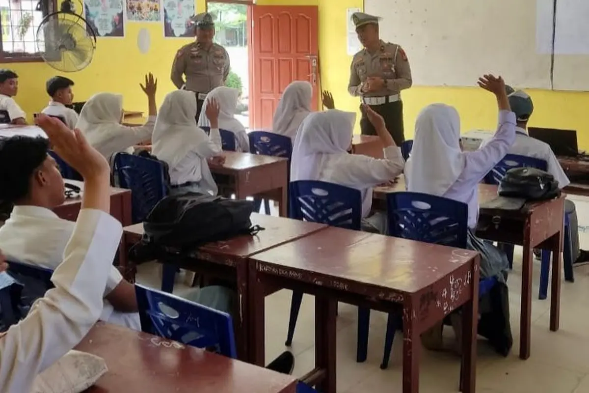 Sosialisasi Pilkada damai dan menjaga harmonisasi guru serta siswa oleh polisi di Rokan Hulu.