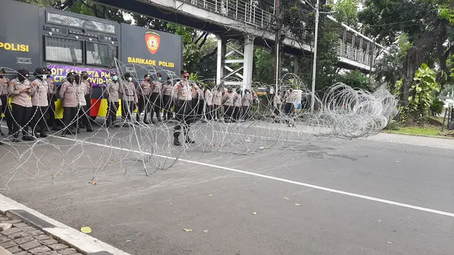 Polisi menutup jalan ketika buruh menyampaikan aspirasi di kawasan Patung Kuda Arjuna Wiwaha, Jakarta Pusat, Sabtu (1/5/2021). (Liputan6.com/Ady Anugrahadi)