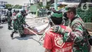 Anggota TNI berbicara dengan seorang warga yang meminta untuk tidak mencopot paksa baliho Rizieq Shihab di sekitar kawasan Petamburan, Jakarta, Jumat (20/11/2020). Pencopotan dilakukan karena menyalahi aturan yang telah ditetapkan. (Liputan6.com/Faizal Fanani)