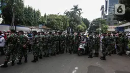 Prajurit TNI menghalau massa yang hendak menggelar demonstrasi 1812 di sekitar Istana Negara, Jakarta, Jumat (18/12/2020). Demo bertajuk Aksi 1812 ini selain menuntut pembebasan Rizieq Shihab, juga mendesak pengusutan kasus enam anggota FPI yang tewas tertembak polisi. (Liputan6.com/Johan Tallo)