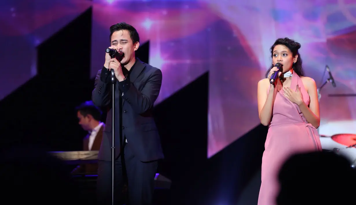 "Ciye banyak orang ketiga di sini ya. Enggak apa-apa lah jadi orang ketiga yah," ucap Ilham (vokalis) HiVi di atas panggung menyapa penonton. (Andy Masela/Bintang.com)