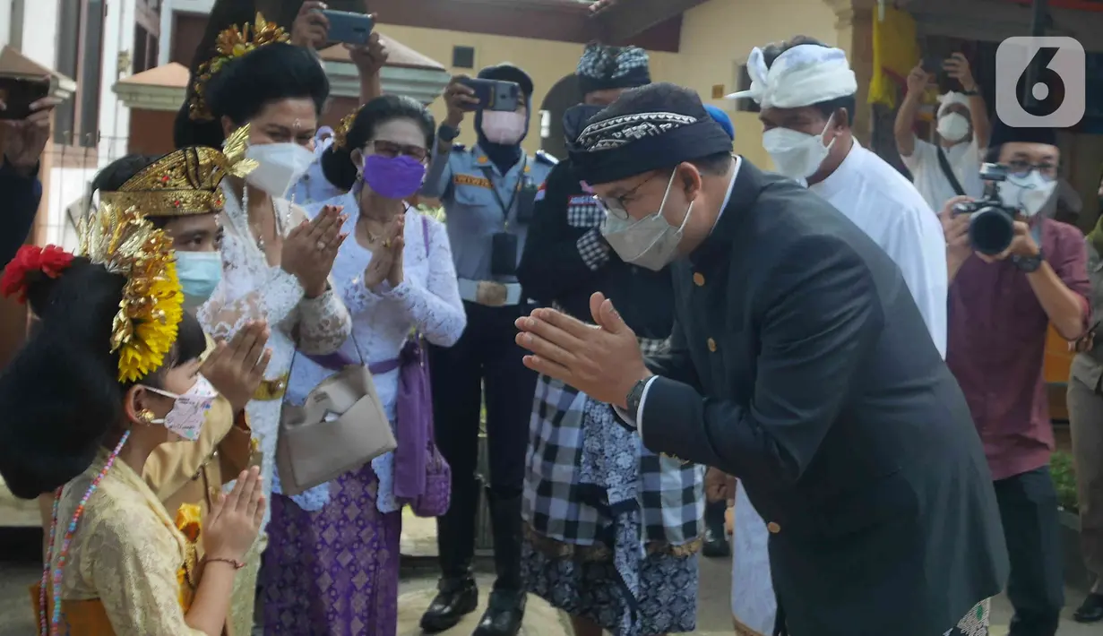 Gubernur DKI Jakarta, Anies Baswedan menyapa seorang anak umat Hindu saat menghadiri Upacara Tawur Agung Kesanga di Pura Aditya Jaya, Pulo Gadung, Rabu (2/3/2022). Upacara Tawur Agung Kesanga merupakan perayaan jelang Hari Suci Nyepi yang jatuh pada Kamis (3/3). (Liputan6.com/Herman Zakharia)