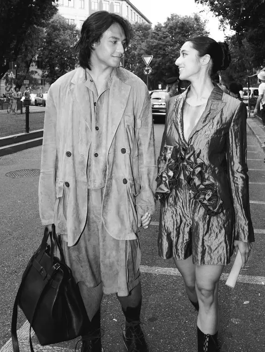 Ia menyempurnakan gayanya dengan combat boots hitam dan tas bahu kulit, mempertegas karakter streetwear mewah ala Emporio Armani.  [@littlemisskhan].