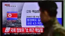Tentara Korea Selatan berjalan melewati sebuah layar TV yang menunjukkan laporan berita di sebuah stasiun kereta api di Seoul, Rabu (6/1/2016). Gempa berkekuatan 5,1 SR terdeteksi di dekat tempat uji coba nuklir Korea Utara. (AFP PHOTO/Jung Yeon-Je)