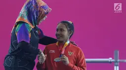 Atlet Para Powerlifting Indonesia, Ni Nengah Widiasih (kanan) saat prosesi medali Womens Up to 41.00kg Asian Para Games 2018 di Jakarta, Minggu (7/10). Ni Nengah Widiasih berhasil melakukan total angkatan 97 kg. (Liputan6.com/Helmi Fithriansyah)