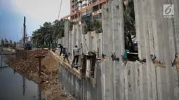 Sejumlah pekerja menyelesaikan pembangunan turap Kali Sunter Jakarta Utara, Selasa (18/12). Pembangunan turap ini merupakan bagian dari proyek normalisasi kali untuk mengantisipasi banjir di musim penghujan. (Liputan6.com/Fery Pradolo)