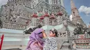 Berkunjung ke candi Buddha terkenal di Thailand, Wat Arun, Ria Ricis dan Moana tampil serasi pakai outfit warna pastel. Ria Ricis dengan gamis ungu, sementara Moana dengan floral top warna ungu senada. [@riaricis1795]
