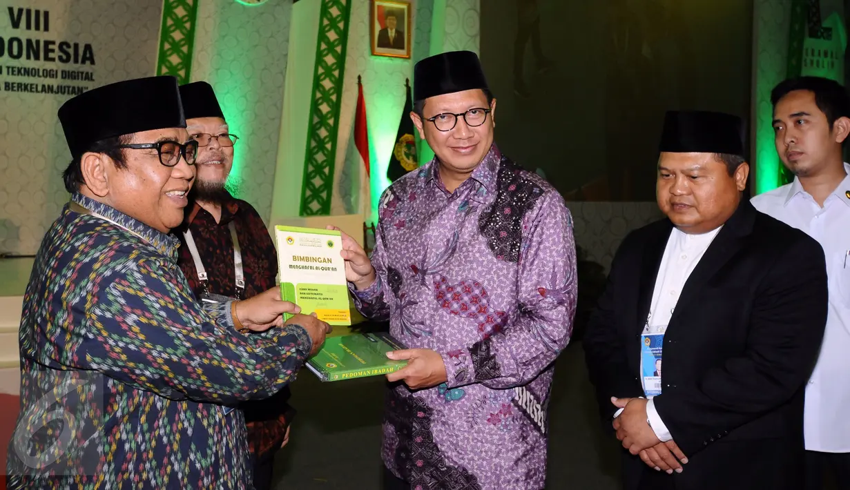 Menteri Agama Lukman Hakim Saifudin (tengah) menerima buku dari Ketua Umum DPP Lembaga Dakwah Islam Indonesia, KH. Abdullah Syam (kiri) usai membuka Munas VIII LDII di Jakarta, Selasa (8/11). (Liputan6.com/Helmi Fithriansyah)
