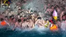 Pengunjung menyaksikan sebuah pertunjukkan sambil mendinginkan diri di kolam renang di Wuhan rovinsi Hubei, China pada 27 Juli 2019. Cuaca yang cukup panas membuat mereka berbondong-bondong menyesaki kolam renang. (Photo by - / AFP)