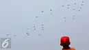Seorang warga menyaksikan pesawat jet saat gladi bersih HUT ke-70 TNI di Cilegon, Banten (3/10/2015). Jelang HUT ke-70 TNI tersebut menjadi daya tarik tersendiri bagi warga untuk menyaksikan secara dekat atraksi TNI. (Liputan6.com/Immanuel Antonius)