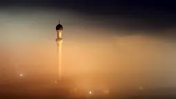 Menara masjid tampak tertutup oleh kabut asap yang tebal di desa Ponijeri, Kota Sarajevo, Bosnia dan Herzegovina, Minggu (27/12). Pemerintah setempat mengimbau warganya untuk tidak beraktivitas di luar rumah. (REUTERS/Dado Ruvic)