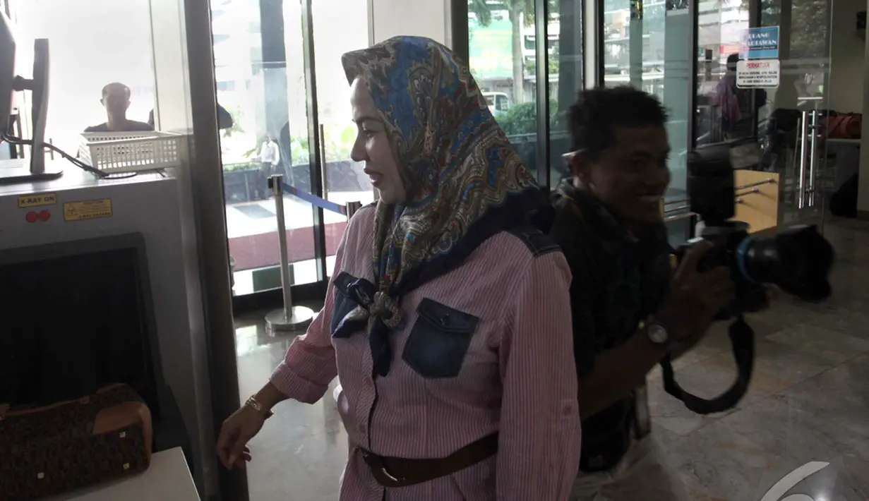 Lia Tri Tirta Sari, istri Muhtar Ependy (orang dekat mantan Ketua Mahkamah Konstitusi Akil Mochtar) tersenyum di Gedung KPK, Jakarta, Jumat (24/10/2014) (Liputan6.com/Johan Tallo)
