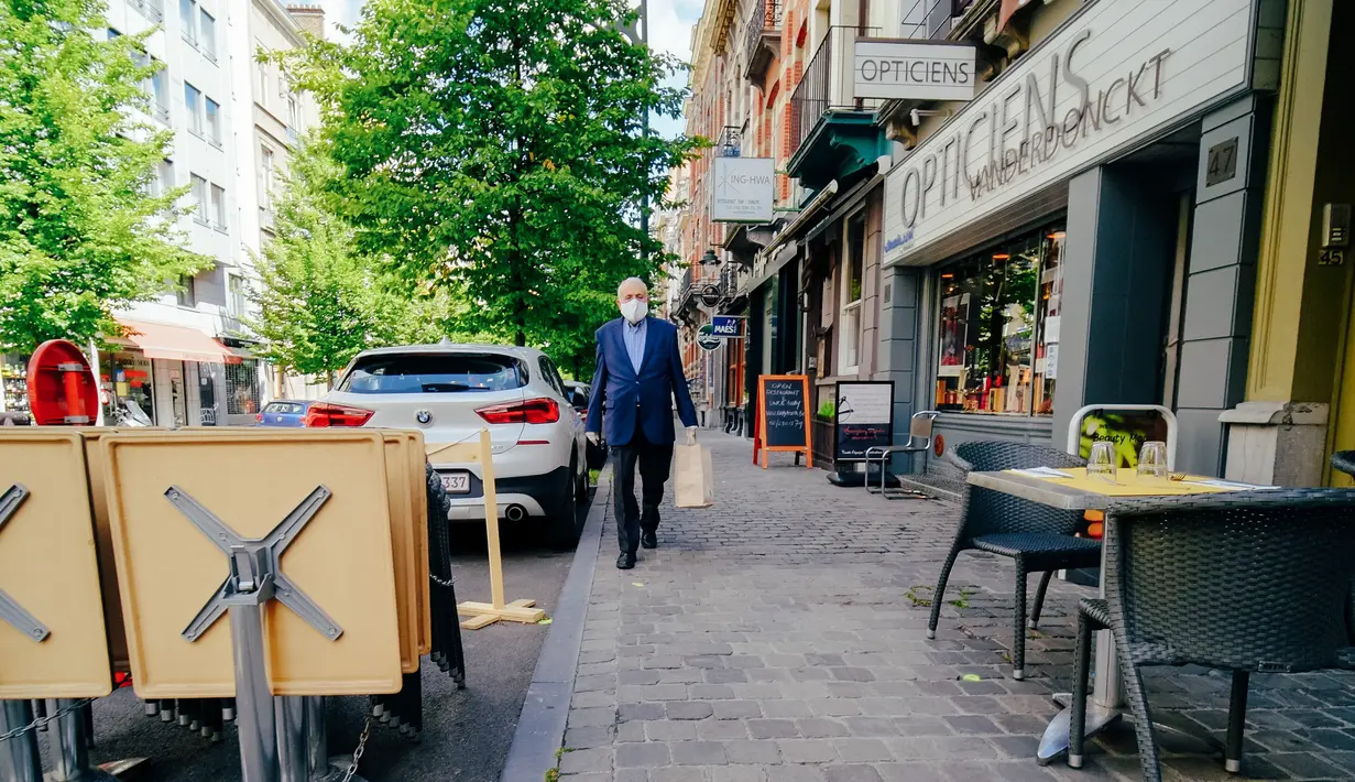 Seorang pria yang mengenakan masker berjalan di Brussel, Belgia, Senin (29/6/2020). Kepala Organisasi Kesehatan Dunia (WHO) mengatakan bahwa semua negara yang hidup dengan COVID-19 akan menjadi suatu kondisi normal baru dalam beberapa bulan mendatang. (Xinhua/Zhang Cheng)