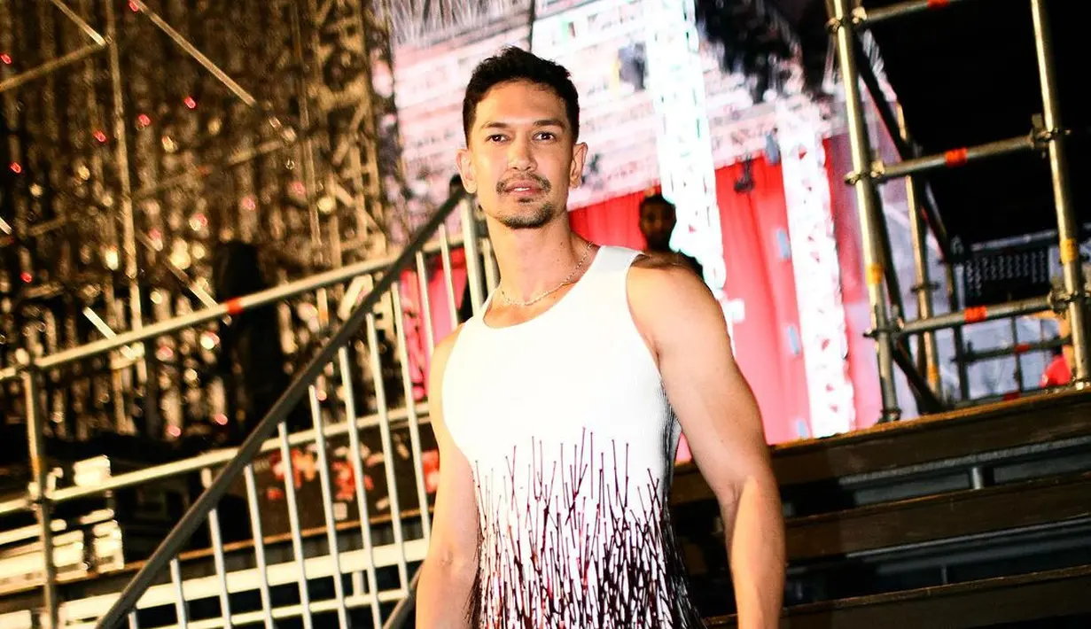 Dimas Beck bikin pangling dengan sleeveless top dengan aksen fringe hyang menampakkan lengan kekarnya. Atasan tersebut dipadukan dengan fringe pants warna merah. [Instagram/dimasbeck]