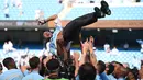 Manajer Manchester City Pep Guardiola dilemparkan ke udara oleh para pemainnya usai melawan Huddesfiel dalam pertandingan Liga Inggris di Etihad Stadium (6/5). (AFP/Oli Scraff)