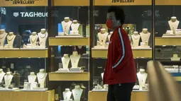 Seorang pria yang mengenakan masker berjalan melewati sebuah toko di Square One Shopping Center di Mississauga, Ontario, Kanada (9/10/2020). Negara itu menambah 378.000 lapangan kerja pada September, meningkat 2,1 persen, jauh melebihi ekspektasi. (Xinhua/Zou Zheng)