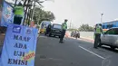 Sejumlah petugas mengarahkan kendaraan yang tengah melintas untuk terlebih dahulu melakukan uji emisi, Jakarta, (23/9/14).  (Liputan6.com/Faizal Fanani) 