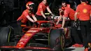 Para mekanik mendorong mobil pembalap Ferrari asal Spanyol, Carlos Sainz, saat mereka berlatih pit stop di Shanghai pada 18 April 2024. (GREG BAKER/AFP)