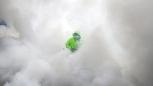 Pekerja yang mengenakan pakaian pelindung mendisinfeksi sebuah desa sebagai tindakan pencegahan terhadap penyebaran COVID-19 di Manila, Filipina, Senin (15/3/2021). Kementerian Kesehatan Filipina melaporkan lonjakan kasus COVID-19 selama lebih dari seminggu. (AP Photo/Aaron Favila)