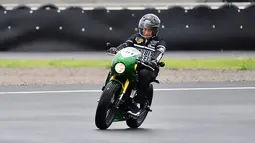 Jokowi mengendarai motor custom dengan warna hijau garapan Katros Garage. Dia mengenakan setelan jaket hitam dan sepatu sneakers saat menjajal sirkuit Mandalika. (Istana Kepresidenan/Agus Suparto)